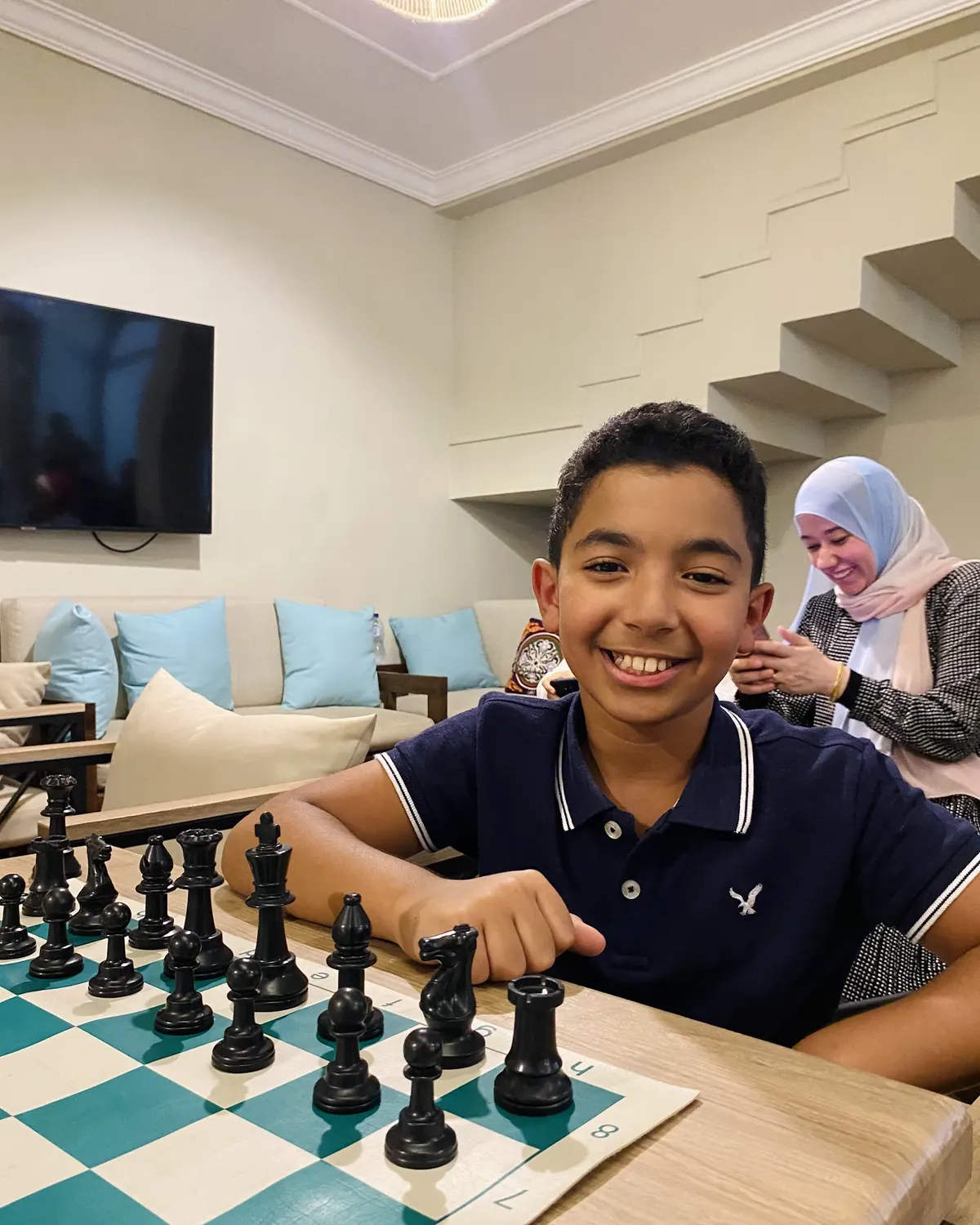 طفل مبتسم أمام رقعة شطرنج في إحدى سيشنز Chess Your Child